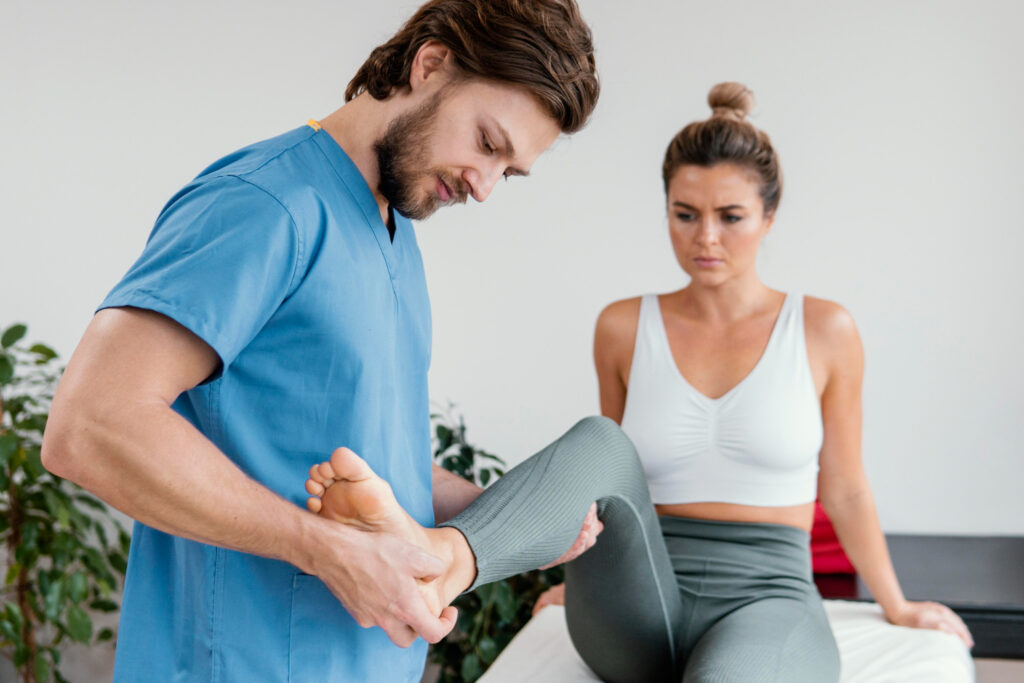 terapeuta osteopatyczny sprawdzajacy ruchy nóg poacjetki